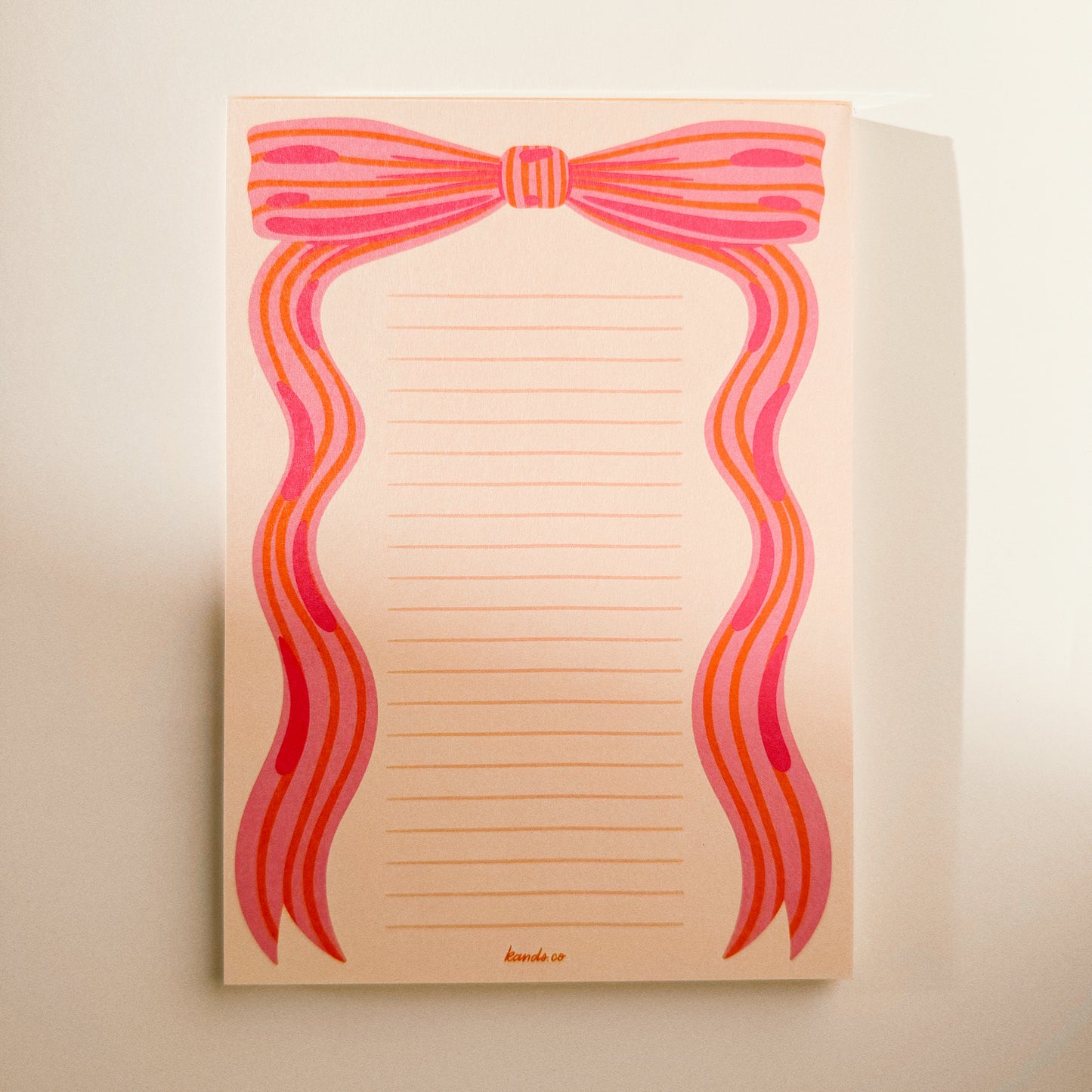Side view of little bow pink notepad showing binding