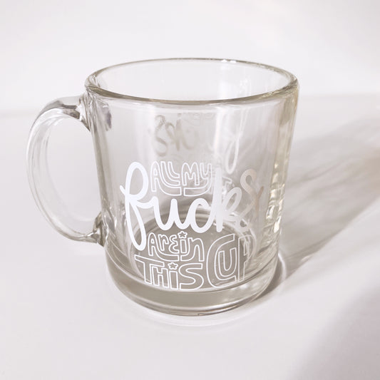 Humorous clear glass mug with 'All My F*cks Are in This Cup' tex