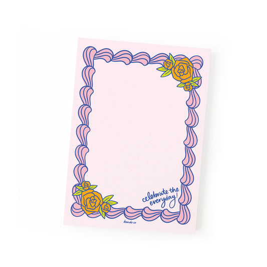 A pink notepad with a decorative border and a frosted design, including a rose and the text 'CELEBRATE THE EVERYDAY'.