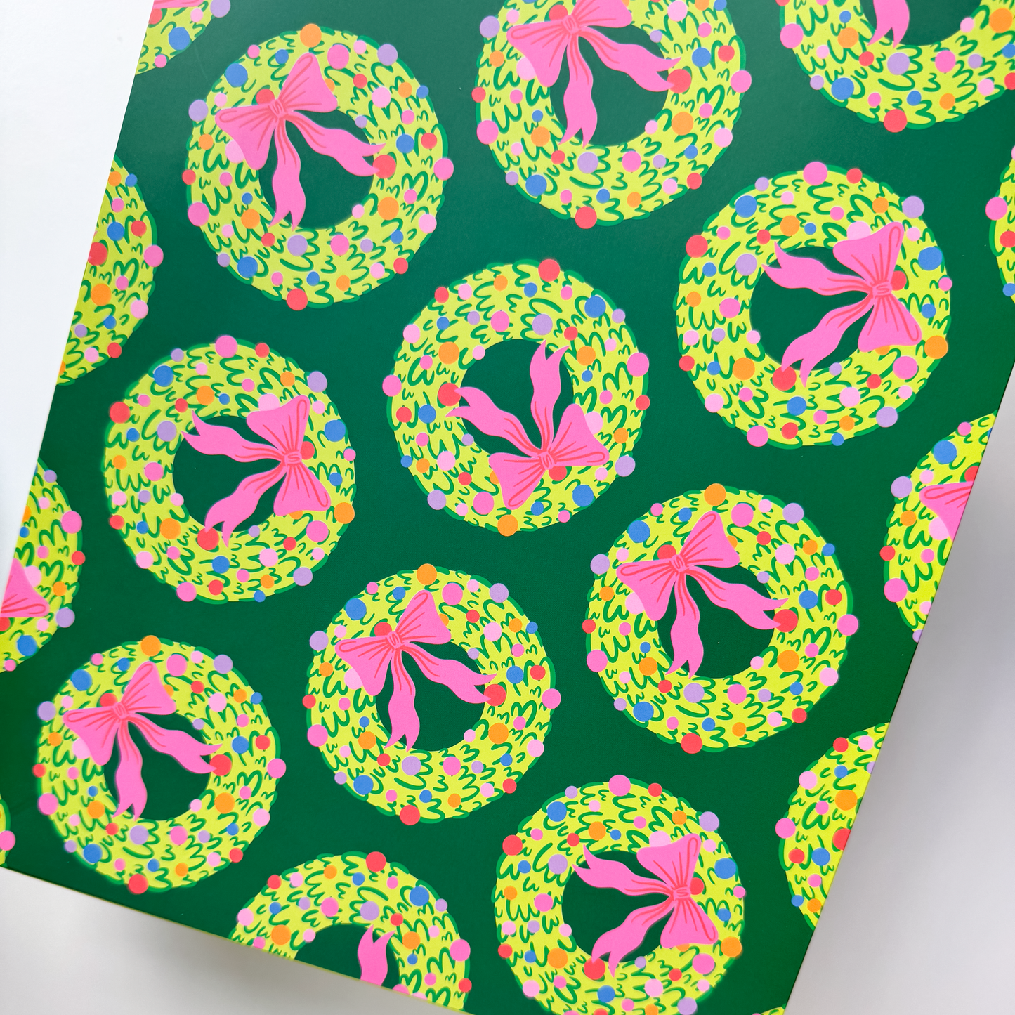 Close-up of rainbow wreath illustration on white gift bag with vibrant colors