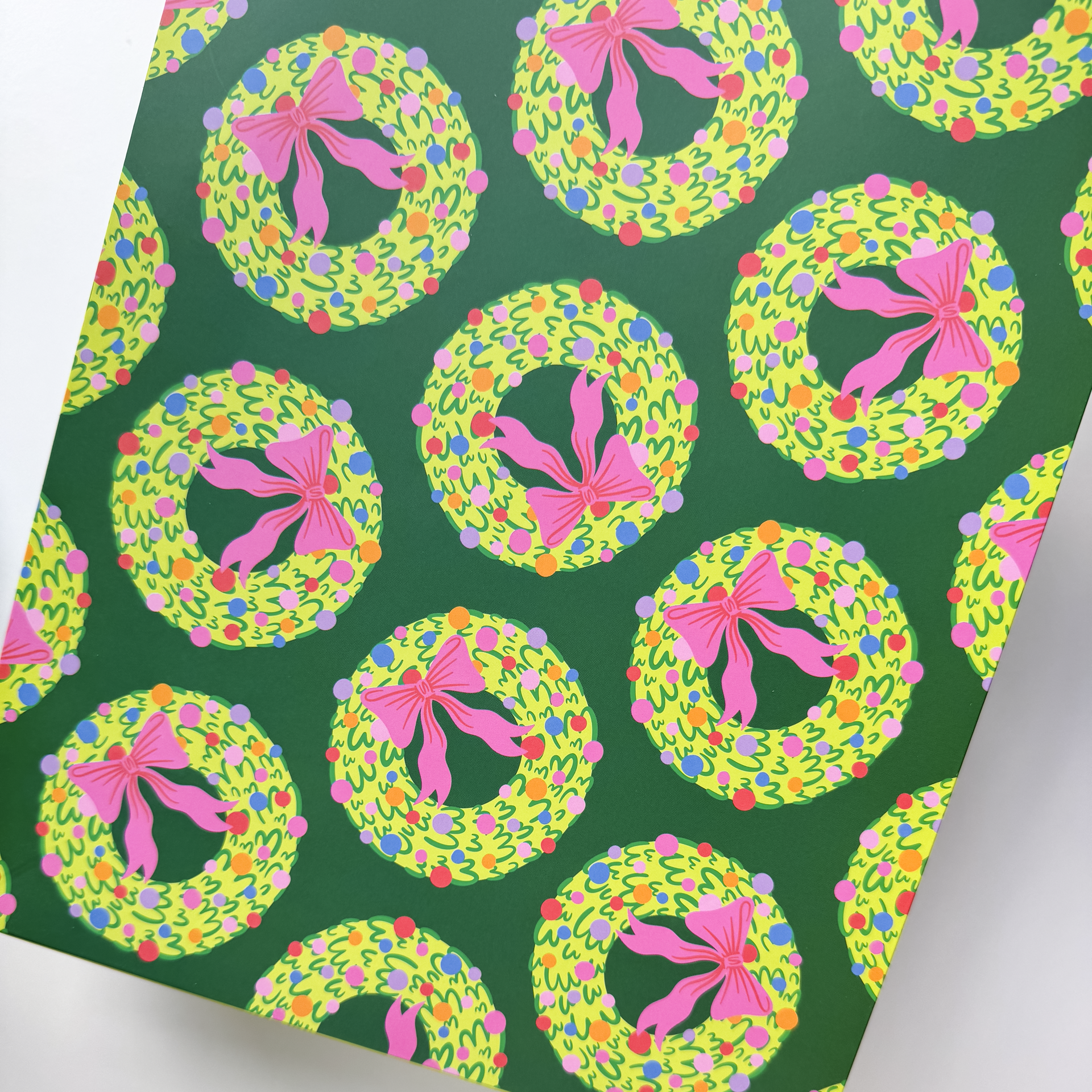 Close-up of rainbow wreath illustration on white gift bag with vibrant colors