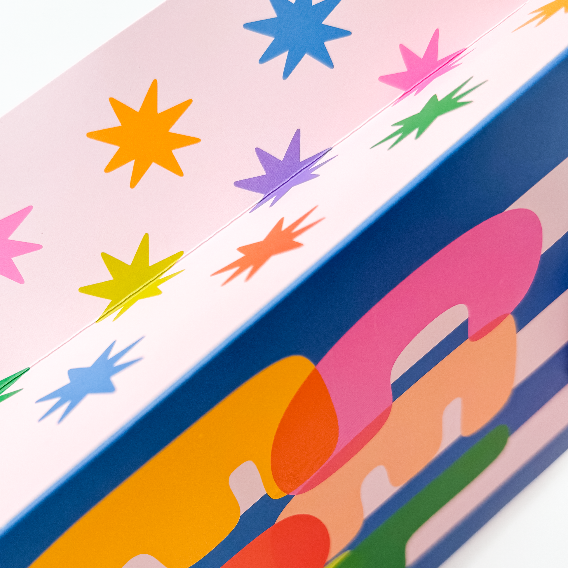 Side view of celebrate gift bag showing vibrant rainbow typography design