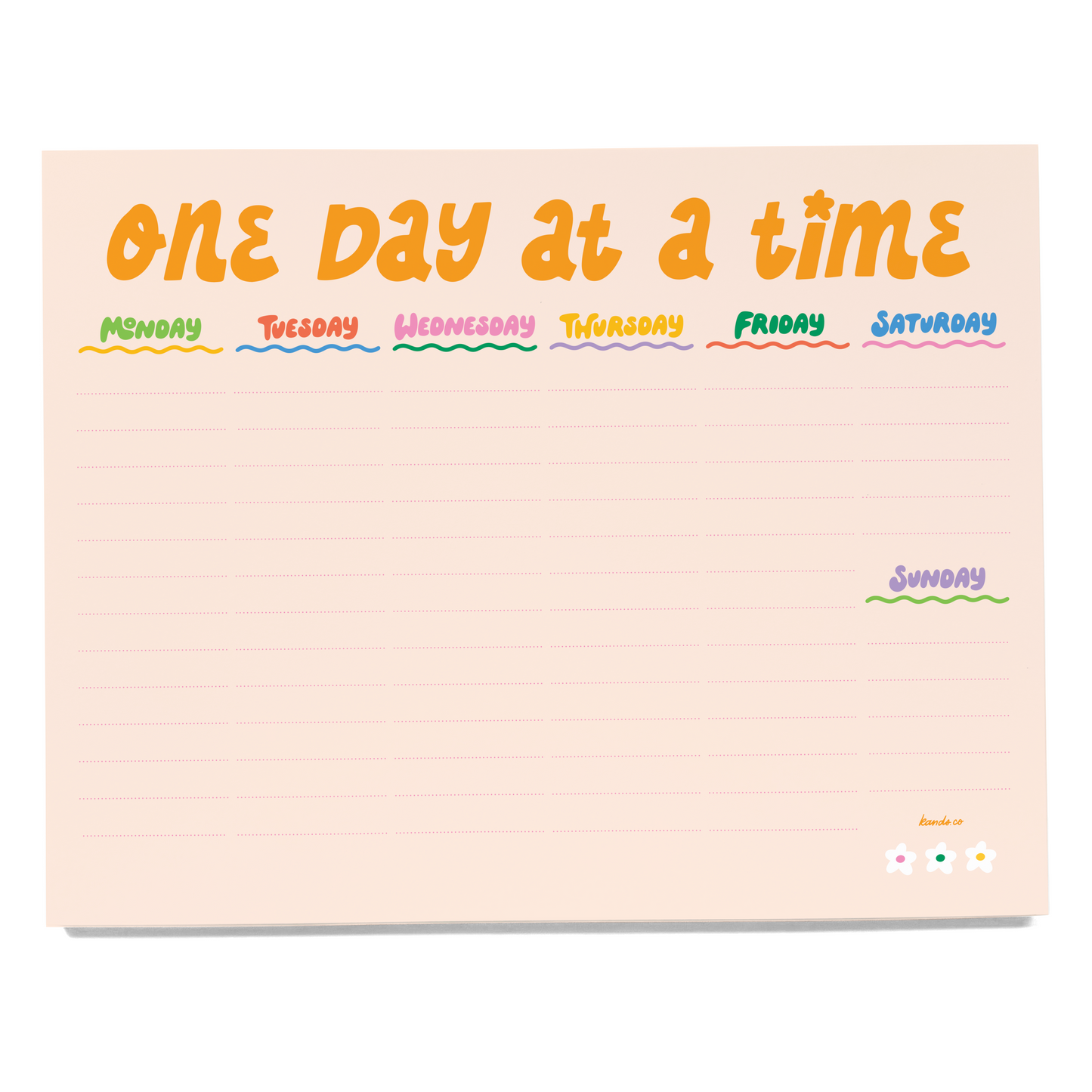 Notepad with 'One Day at a Time' days of the week layout on a light pink background